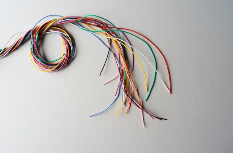 Close-up photograph of a messy, tangled knot of computer cables, symbolizing a technical bottleneck and complex developmen...
