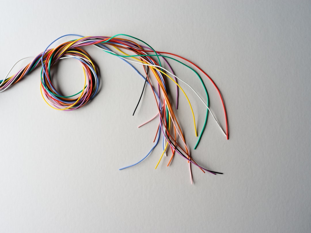 Close-up photograph of a messy, tangled knot of computer cables, symbolizing a technical bottleneck and complex developmen...