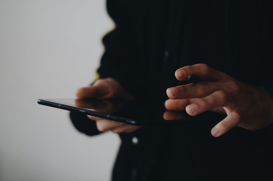 A person in a modern setting using a tablet to browse a niche real estate website featuring waterfront properties, highlighting the digital marketing aspect.